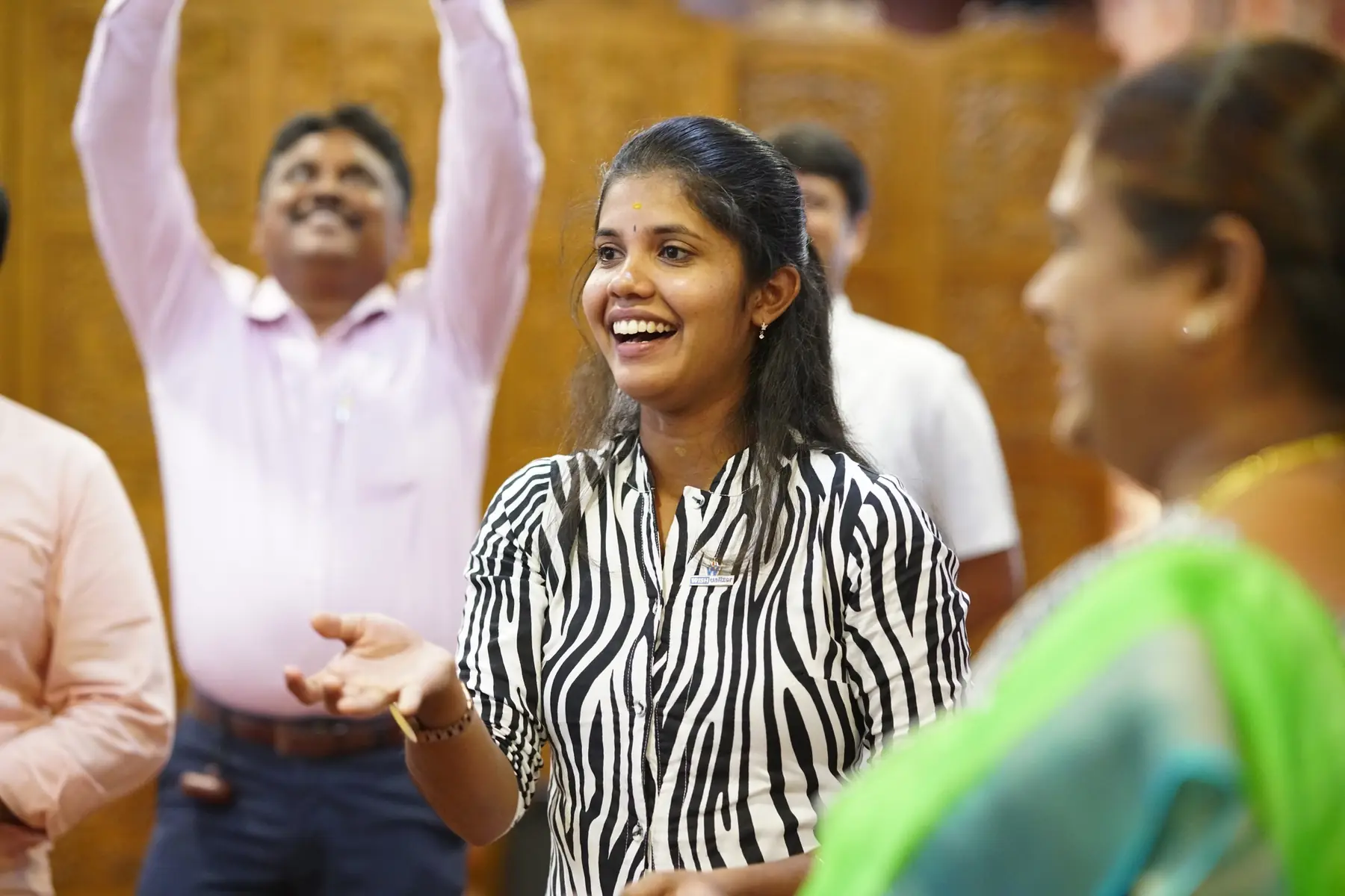 Two participants laughing with their arms raised during a session