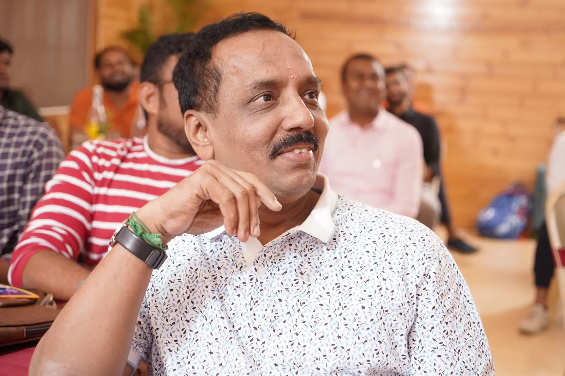 A participant smiling as he listens