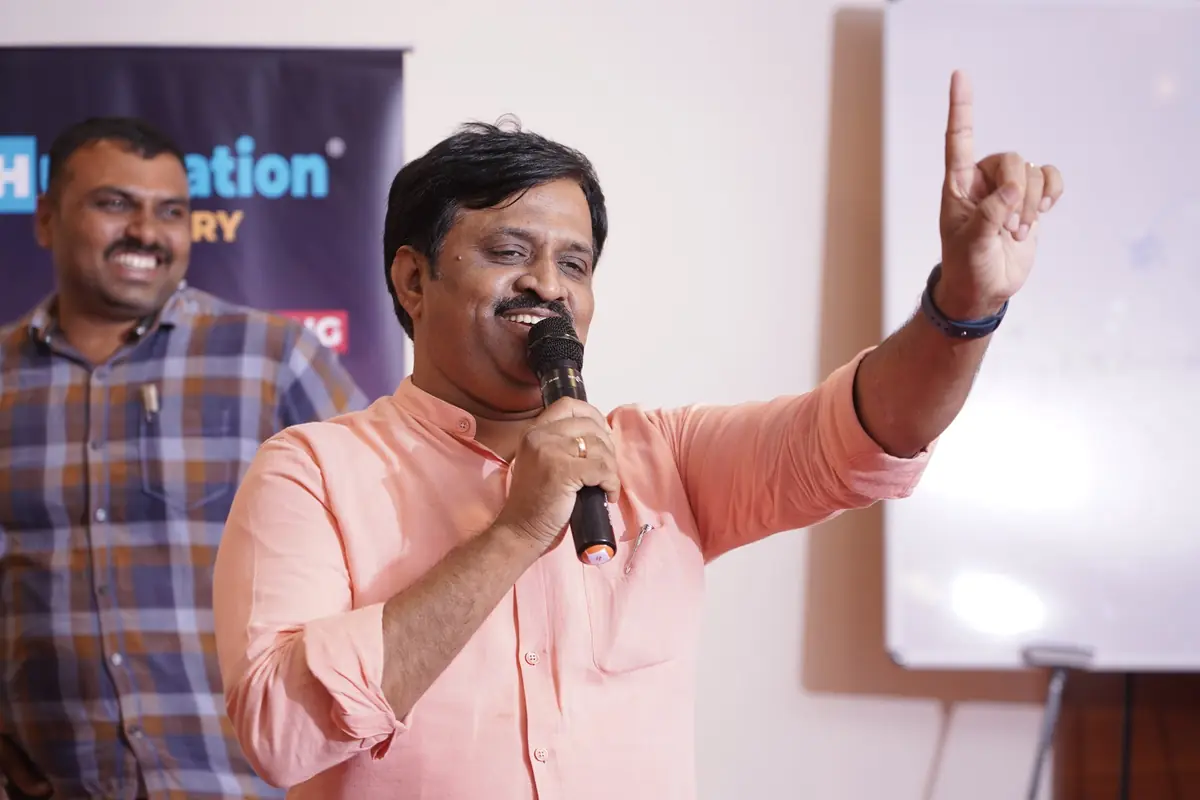 Surekaa Sundar on stage, pointing upward, microphone in hand